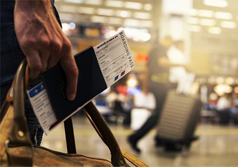 Traveler with suitcase, passport, and boarding pass